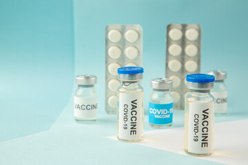 Top view of vaccine medical ampoules packed pills for Covid- treatment on pastel blue background
