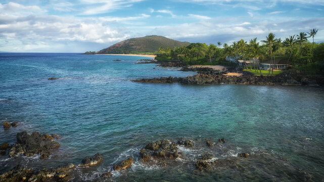 Aerial drone view over Makena Cove approaching Makena Beach in Kihei, on the island of Maui in Hawaii. Shot during spring, April, 2023 during early morning, with nearly no tourists on the beach yet.