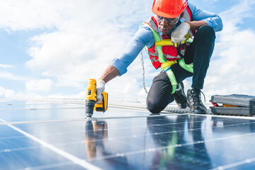 African American engineer maintaining solar cell panels on factory building rooftop. Technician working outdoor on ecological solar farm construction. Renewable clean energy technology concept