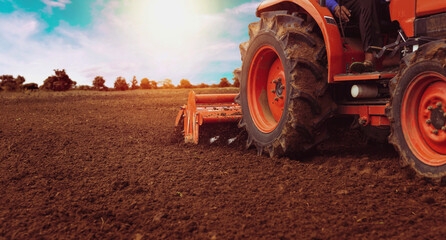 Farmers are using tractors to till the soil to prepare the land for planting.