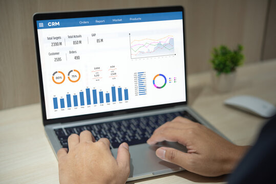 Man using computer laptop software with graphs and charts showing sales data. CRM Customer Relationship Management. Business Management Analysis Service Concept management.