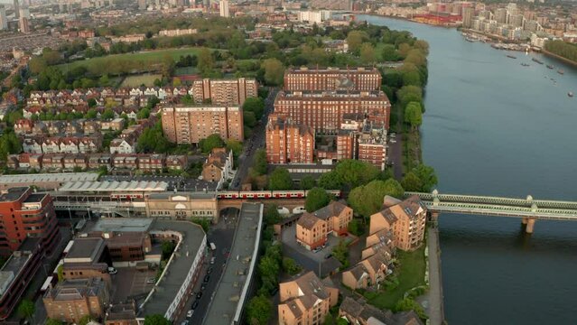 Aerial shot alongside District line train going over the thames river on Fulham railway bridge Putney