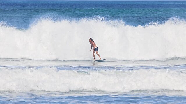 One Surfer Riding on Surf in Beautiful Ocean Waves Slow Motion. Cool Paradise Adventure Leisure in Island. Fun Sunny Day of Surfboarder in Blue Big Ocean. Pro Healthy Style with Splashing Sea Spray 4k
