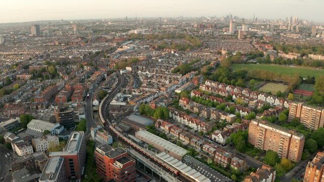 Aerial shot over District line underground train in west london neighbourhood Fulham looking towards the city skyline