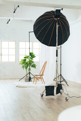 Antique chair and lighting equipment placed in the room of the photography studio.