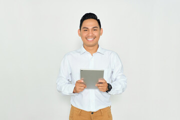 Portrait of happy young Asian man in formal wear holding digital tablet and looking at camera with smiling face isolated on white background