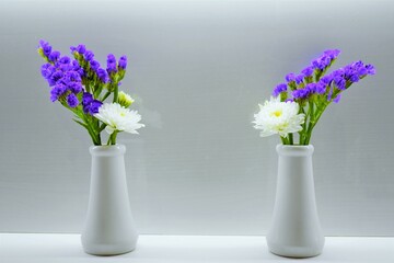 ホワイトバックに花立に活けられた白い菊と紫のスターチスの仏壇用の花、２セット