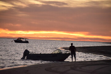 Fototapeta premium Boat and man at sunset