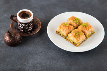 Traditional pistachio baklava with Turkish coffee on black background,top view
