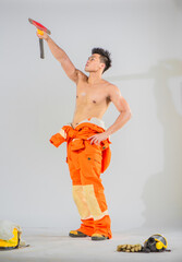 Professional firefighter stands holding an iron axe and lodge to the top with a firm grip displaying strength and readiness to tackle any firefighting challenge.