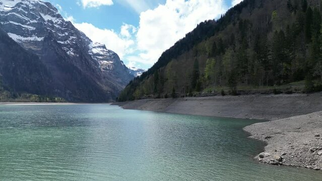 Blue alpine lake with behind snow-capped mountains. Switzerland. Slow motion