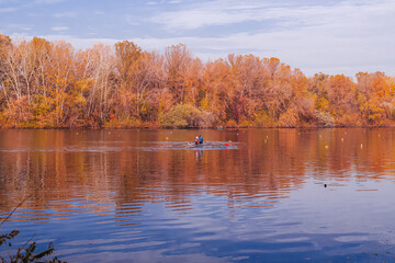 The Dnieper River in the City of Dnepr in autumn. Foggy morning. spit on the embankment of victory. Trees branches with yellow leaves, bird fishermen near the river