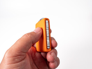 Modern wireless orange ignition key in hand on a white background. Wireless key to start the...