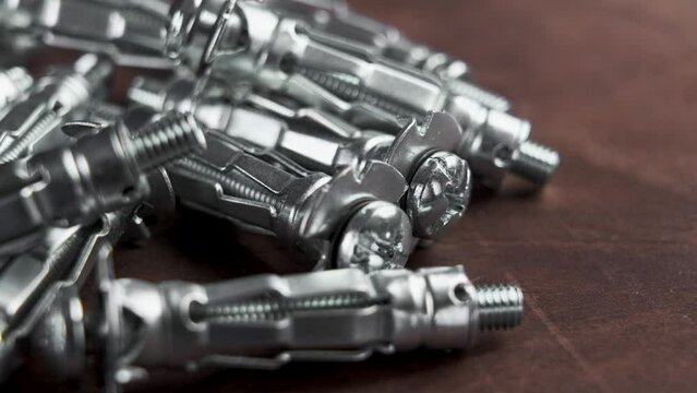 New zinc plated molly anchors for fastening to drywall on a wooden surface. Rotation