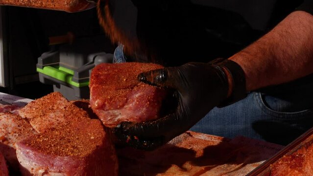 Slow motion seasoning of pork meat at a grill festival