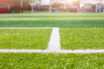 Obraz premium Selective focus to white lines on green artificial grass football fields. Artificial turf soccer field, green background. Outdoor field.
