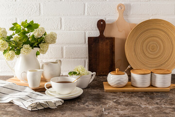 Beautiful front view of various kitchen utensils and cutting boards on a dark marble countertop...