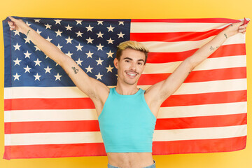 Happy gay man raising a north america national flag