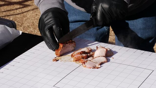Slow motion shot of slicing meat at a grill festival