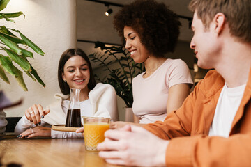 Smiling waitress serving drinks for couple in cafe