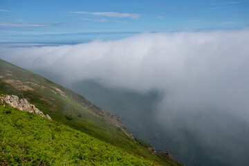 Fototapeta na wymiar View from the summit of Bray Head with sea mist rolling over the coastline