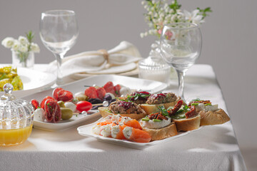 Festive table with white tablecloth and appetizers