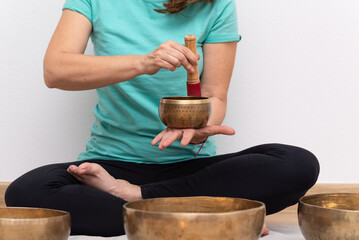 Close-up woman hands holding and playing a tibetan singing bowl.