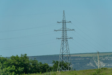 High voltage towers with sky background. Power line support with wires for electricity transmission. High voltage grid tower with wire cable at distribution station. Energy industry, energy saving