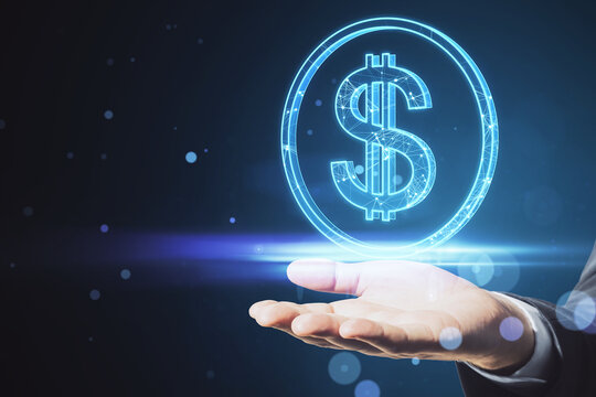Close up of businessman hand holding glowing round dollar sign on blurry blue bokeh background. Online banking, money and invest concept.