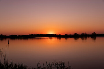 a beautiful reflection of the colorful sky in the water at sunset