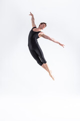 Ballet Dancer Young Man in Black Dance Suit Posing in Flying Ballanced Dance Pose Studio.