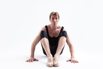 Fototapeta na wymiar Closeup Image of Male Ballerino Dancer Sitting While Practising Stretching Exercices In Black Sportive Tights in Studio