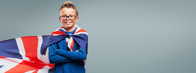 Smiling superhero boy with British flag cape