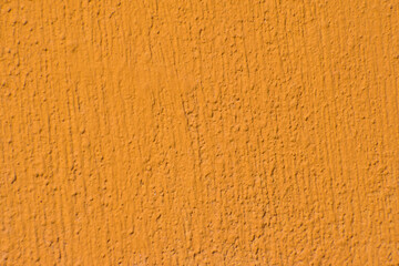 Colorful concrete wall, bright yellow vintage style paint cement background with small details of texture. Close Up