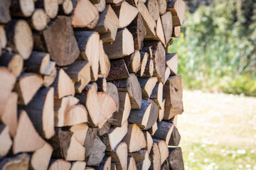 Background of sawn and split firewood, sunny day. Heating and ecological