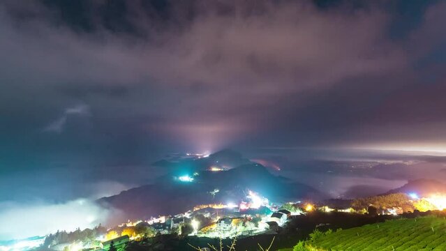 Timelapse - Flowing fog above the town lights with the tea garden rows scene