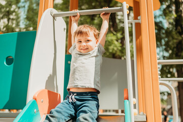 Boy hanging on slide in playground