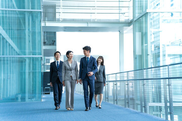 歩くスーツを着た複数のビジネスマン