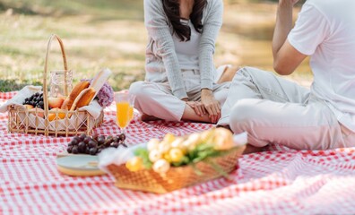 Happy asian couple travel. Woman taking photo of his boyfriend picnic time in park holidays vacation.