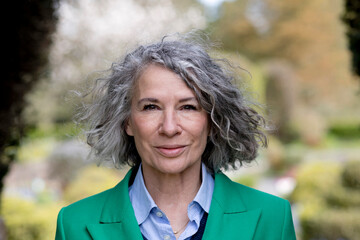 Smiling senior woman with grey curly hair, portrait
