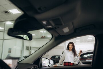 Fototapeta premium Car dealer woman. Auto dealership and rental concept background