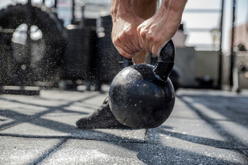 Man lifting kettlebell at rooftop gym