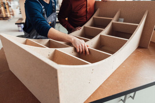 Businessman with carpenter examining wood at workshop