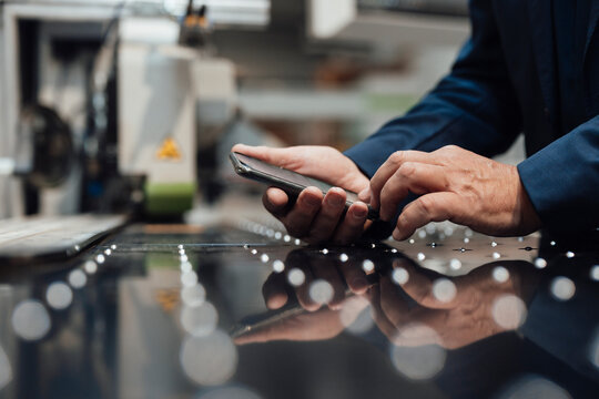 Businessman Using Smart Phone At Industry