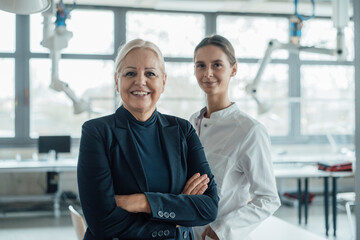 Happy businesswoman standing by colleague in laboratory