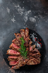 T-bone or porterhouse grilled beef steak with spices and herbs. vertical image. top view. place for text