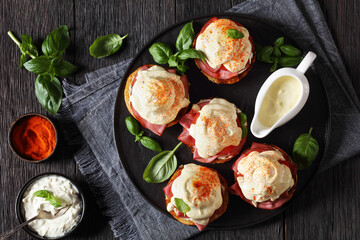 Eggs Benedict on black plate, top view