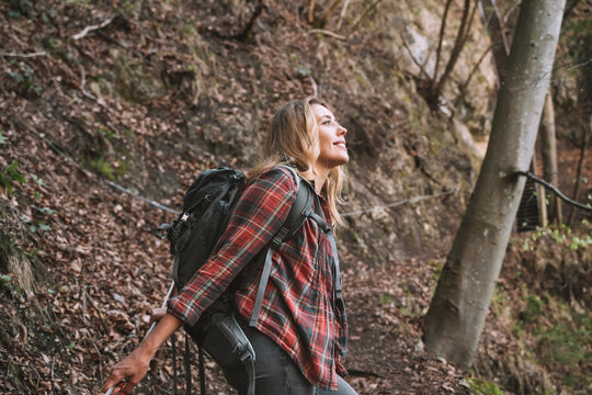 Smiling blond backpacker exploring forest
