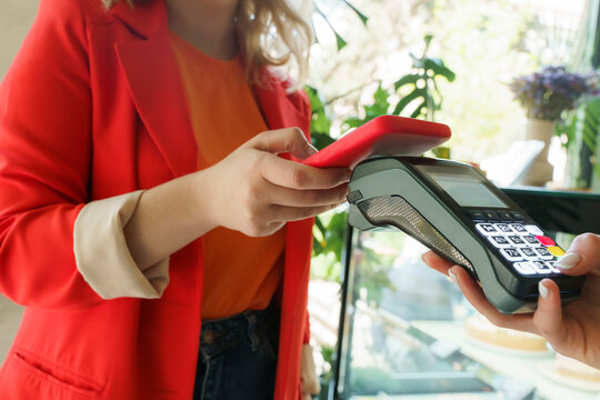 Woman making payment through smart phone at cafe