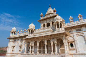 Fototapeta na wymiar Beautiful view of Jaswant Thada cenotaph, Jodhpur, Rajasthan, India. Built out of intricately carved sheets of Makrana marble, they emit a warm glow when illuminated by the Sun. Blue sky background.